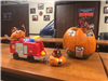 Pumpkin decorated as house on fire; other pumpkins decorated as firefighters with a small fire truck