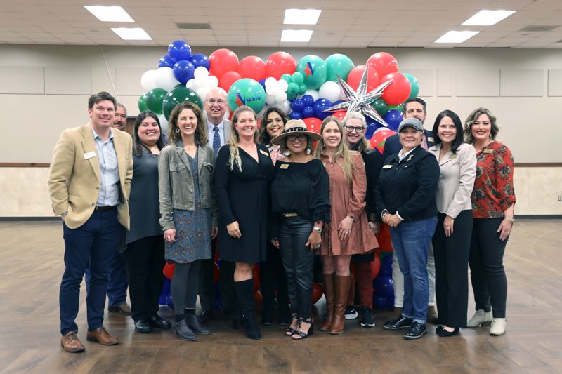 Group photo with balloon backdrop with KVB logos on some balloons