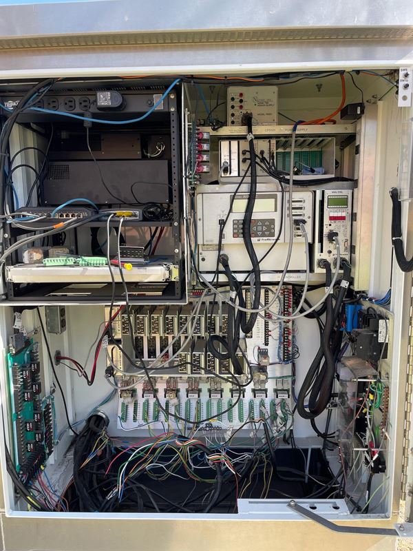 A large metal cabinet-style box containing a variety of wires and electronics