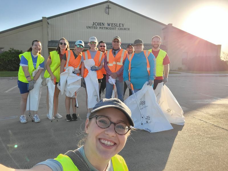 Group photo; people in safety vests with trash bags in front of John Wesley United Methodist Church