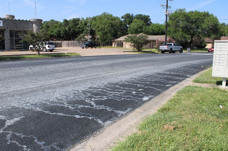 A black street covered in streaked white residue
