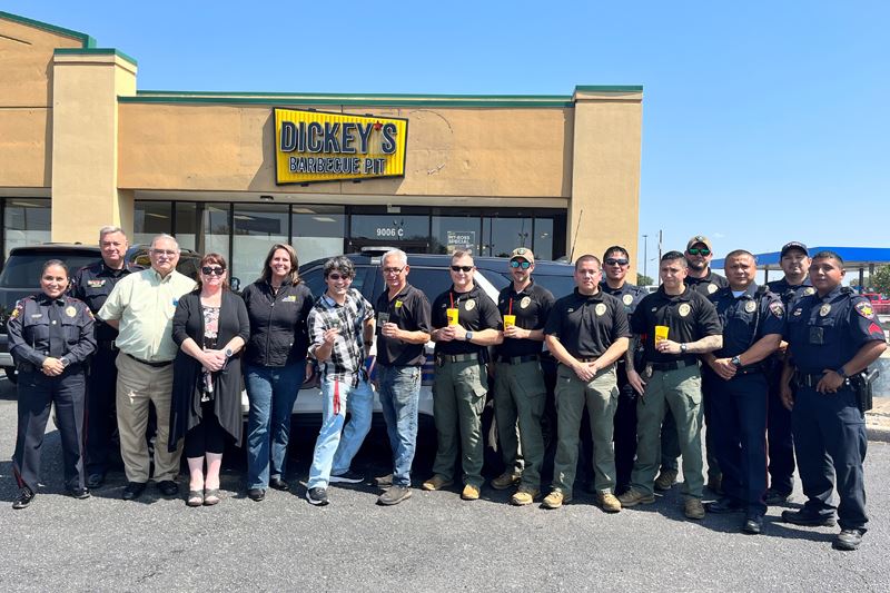 Large group photo with most wearing police shirts or uniforms at Dickey's Barbecue Pit