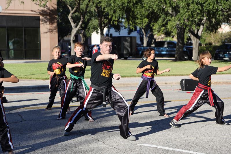 Kids perform karate moves in front of De Leon Plaza
