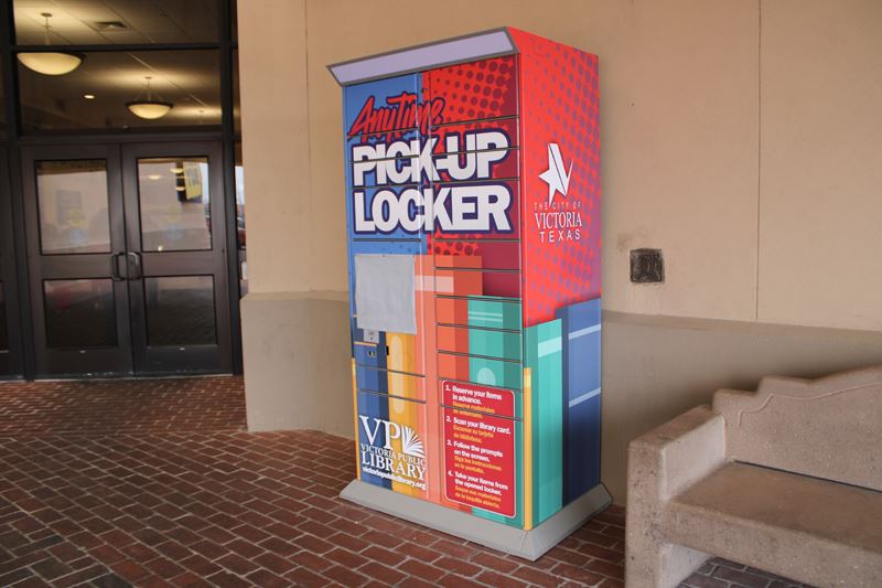 A pickup locker at the Victoria Mall with colorful images of books, the library logo and City logo