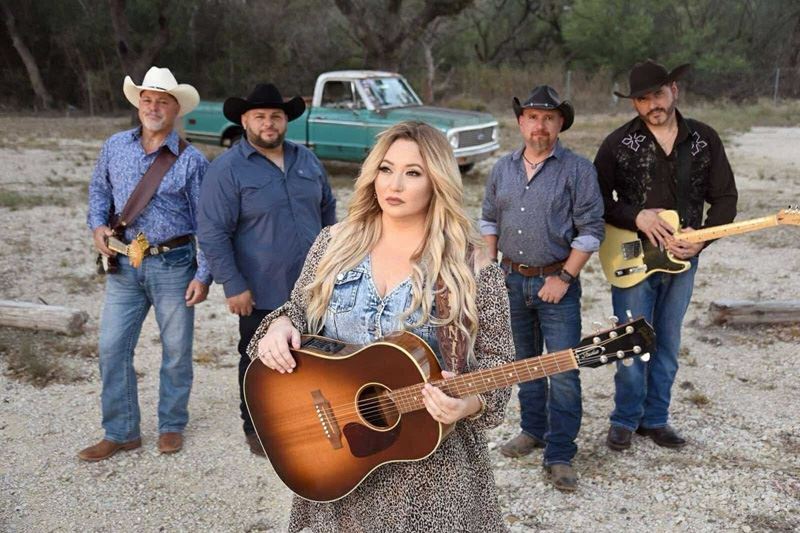 Band photo featuring a female lead guitarist and four other people