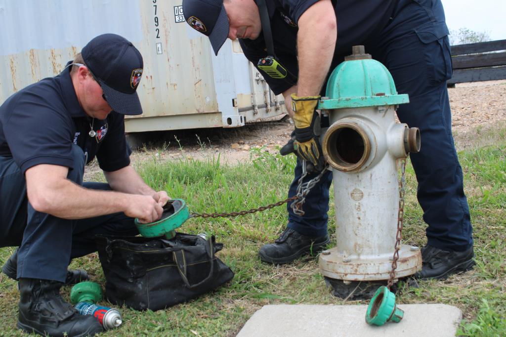 Fire department employees check fire hydrant