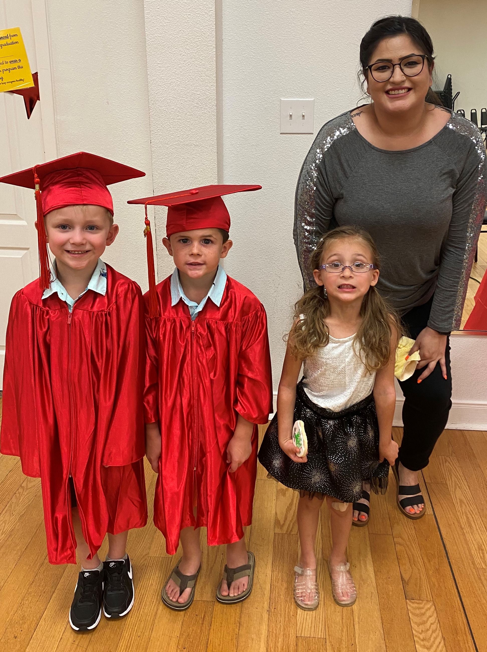 Rebecca Sevier with 3 small children, 2 in graduation regalia