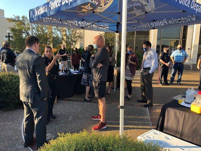Police and residents mingle near a Victoria Police Department booth in the City Hall courtyard.