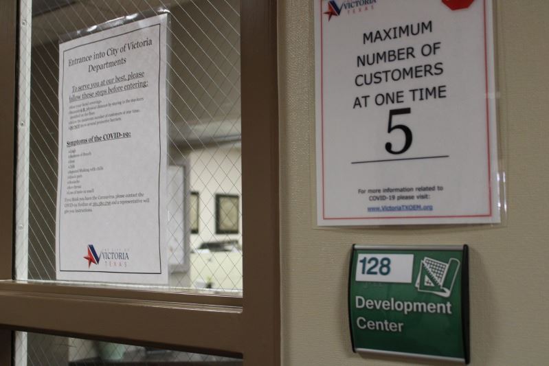 Exterior of the Development Services office with a sign indicating the maximum occupancy is 5 people