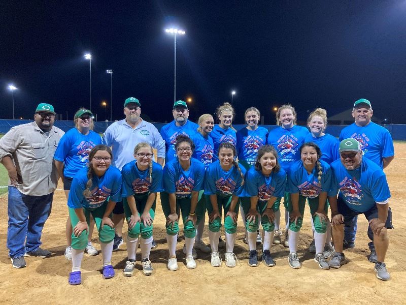 Group of girls in softball uniforms pose for photo