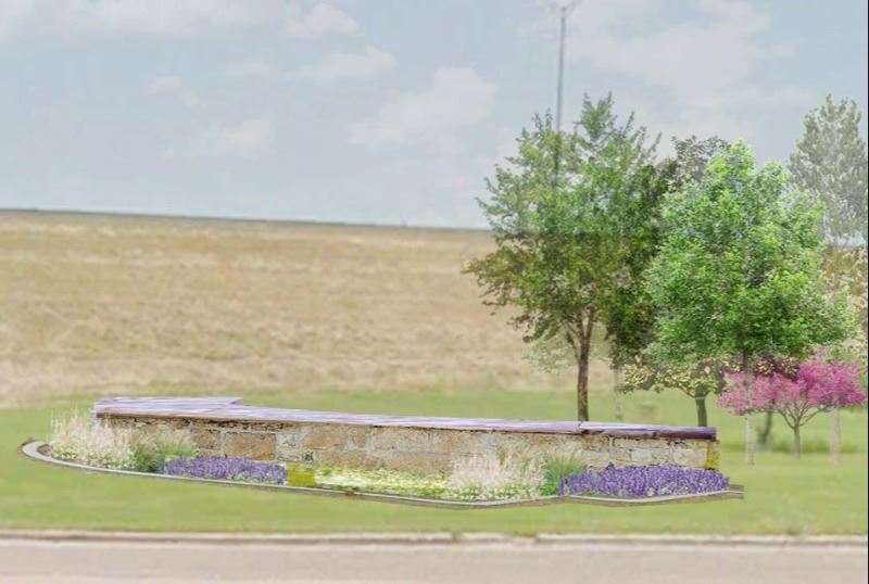 Flowerbed with low decorative brick wall and trees in the background