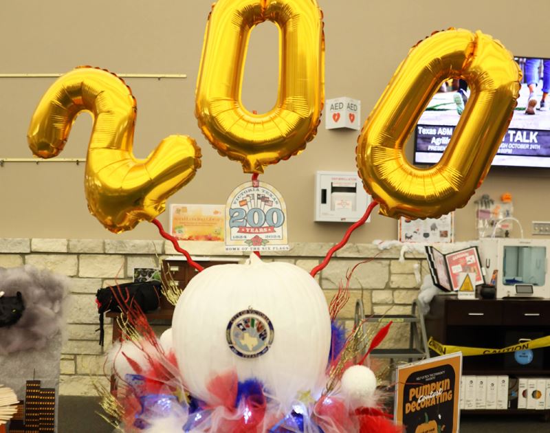 Pumpkin painted white and with large balloons spelling 200 on top, with red and blue frills Opens in new window