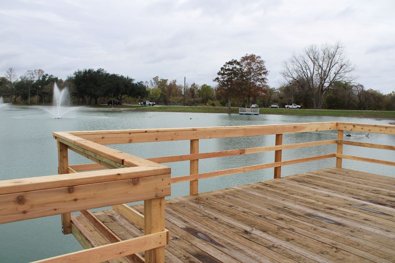A wooden boardwalk over the edge of the duck pond