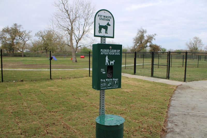 A disposable bag dispenser. Sign reads Pet waste station. Please clean up after your dog.