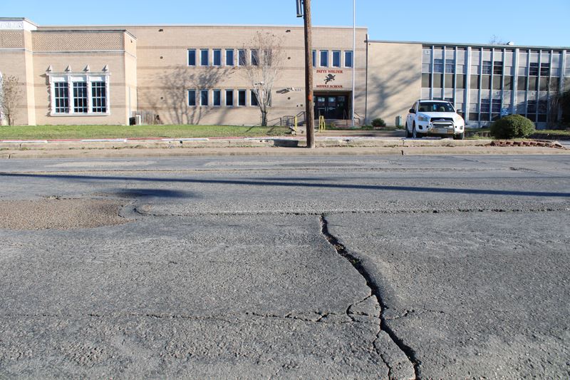 A deep crack runs perpendicular through North Street in front of Patti Welder Middle School