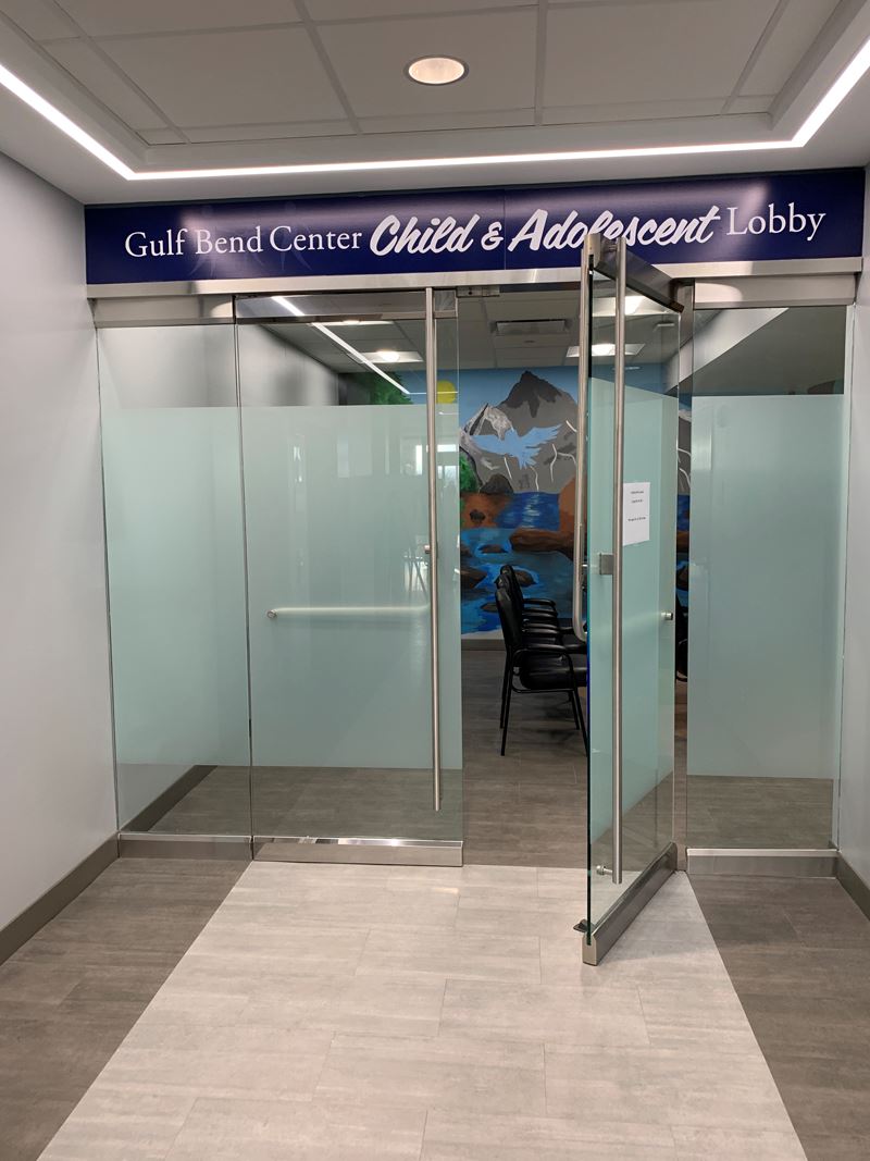 Sign over an indoor open door reads Gulf Bend Center Child and Adolescent Lobby