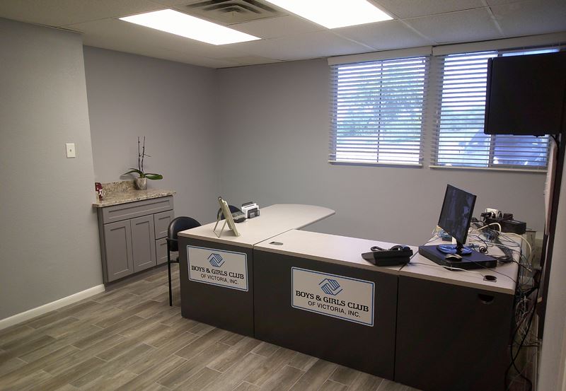 An office. A sign on the desk reads Boys and Girls Club of Victoria Inc.