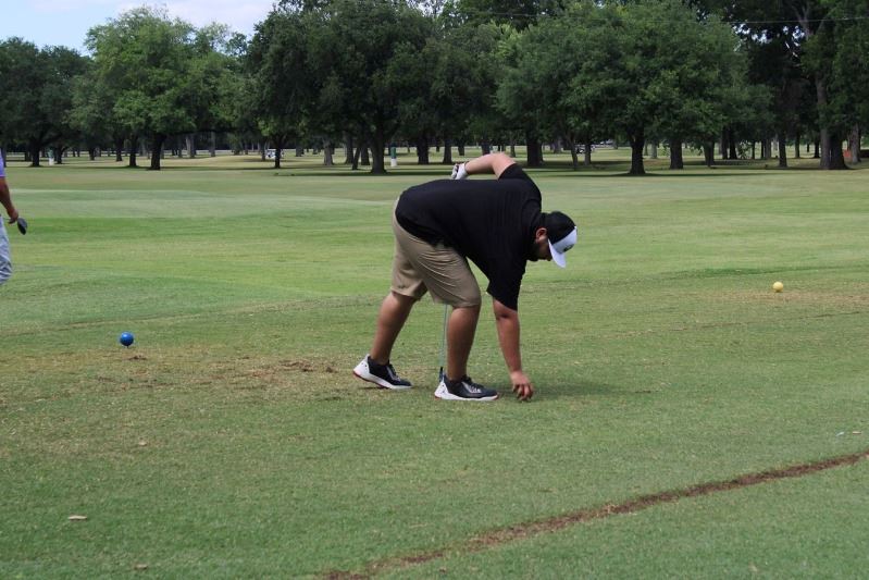Man placing golf ball on tee at golf course