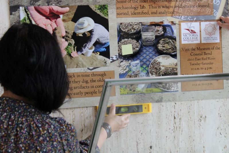 Woman uses bubble level to adjust sign