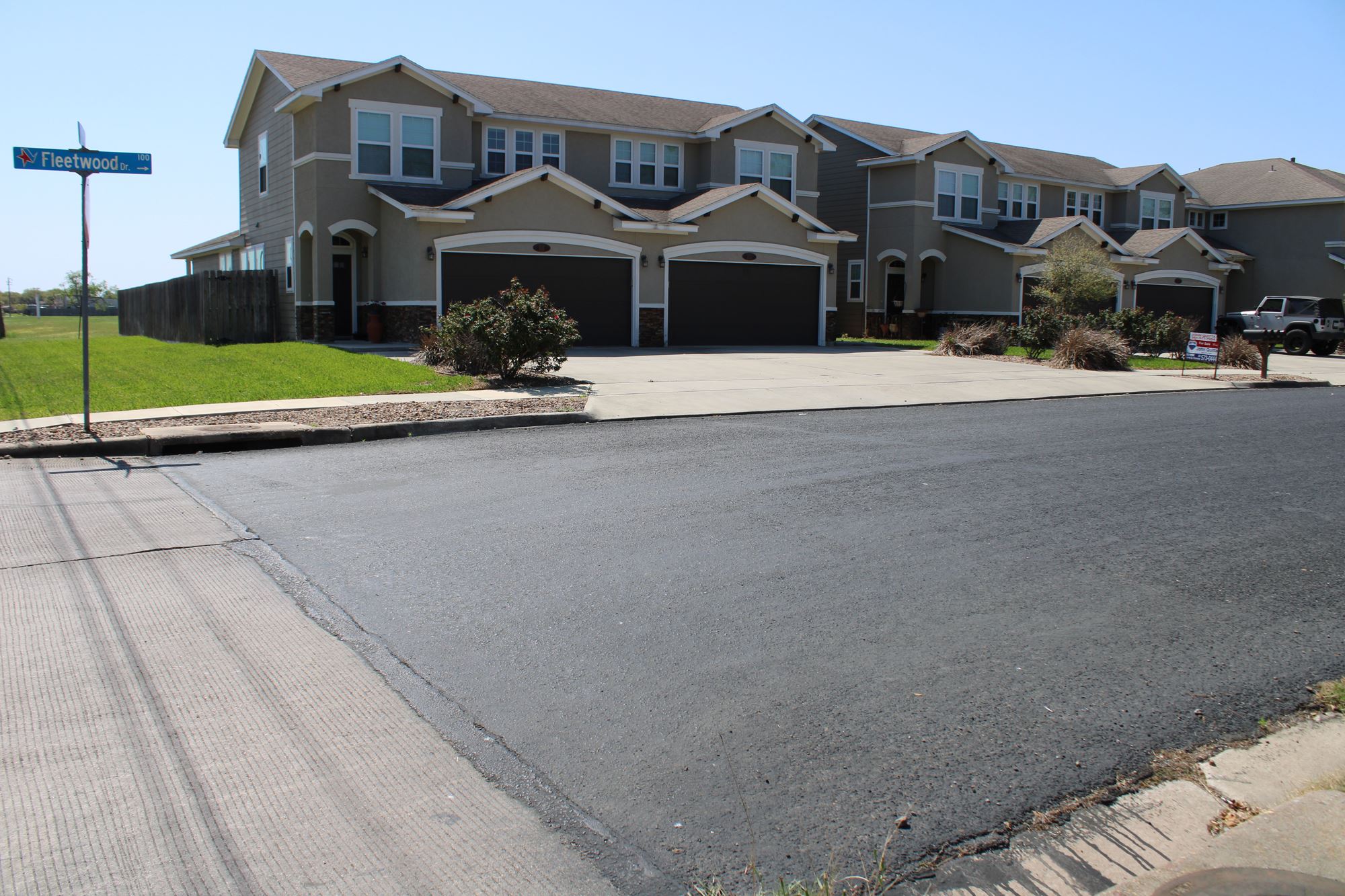 At the entrance to a subdivision, the street changes to a black, smooth surface.