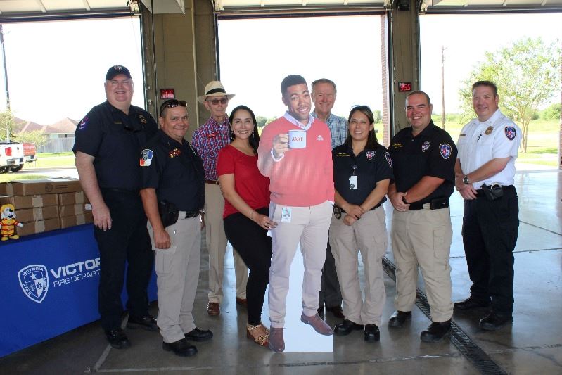Group photo with cutout of Jake from State Farm. Some people wear Fire Department shirts.