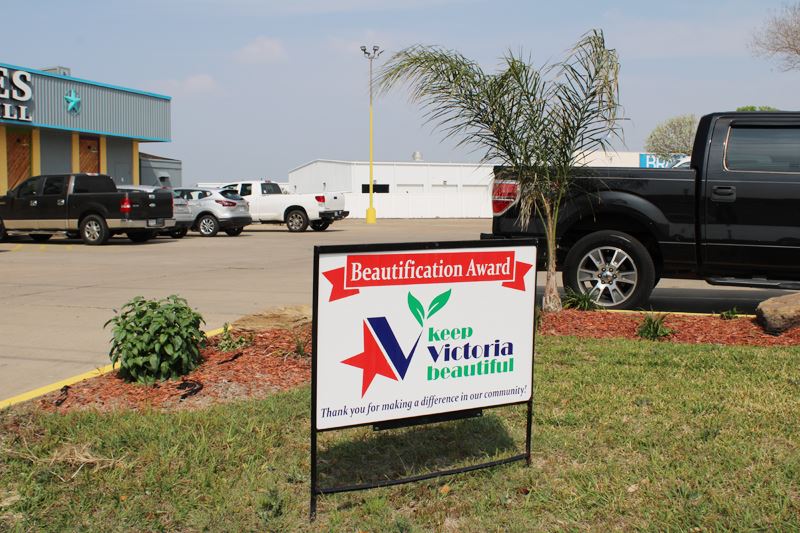 KVB sign in front of wraparound flowerbed with palm tree at Los Reyes Mexican Grill.