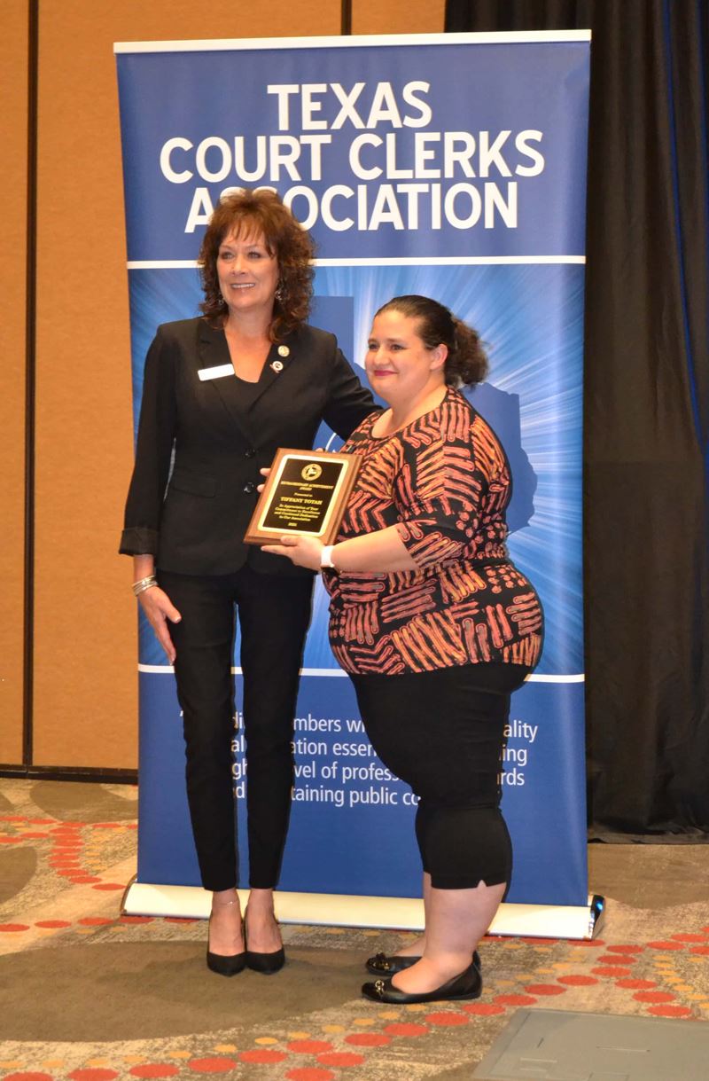 A woman accepts a plaque