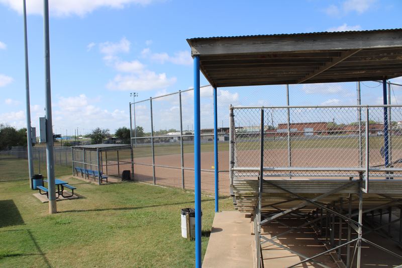 A fenced softball field in a wide-open area