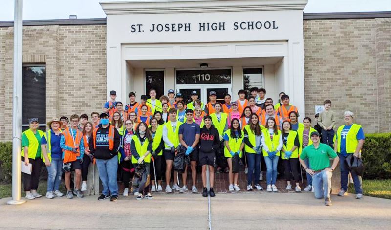 High school students in safety vests pose in front of St. Joseph High School